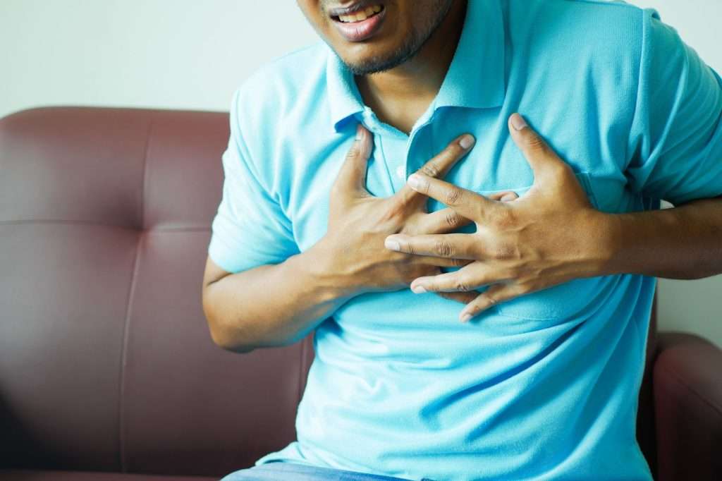 Ultra Bann A close-up image of a man clutching his chest, indicating heart pain or discomfort